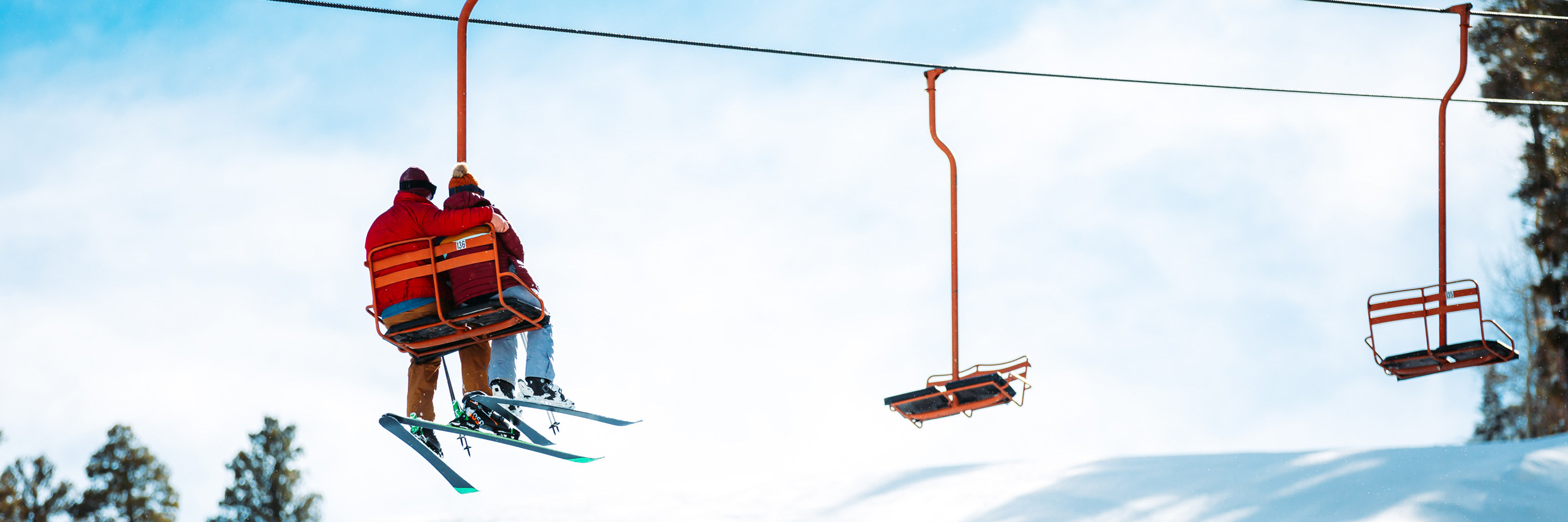 two skiers riding a chairlift