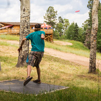 person throwing disc at red river disc golf course